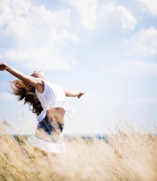 Young woman in casual clothing standing in rye field and enjoying sunshine on summer day with blue sky at background Young woman in casual clothing standing in rye field and enjoying sunshine on summer day with blue sky at background. Woman natural beauty and summer nature concept